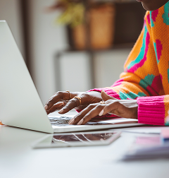Person typing on a laptop at a white desk